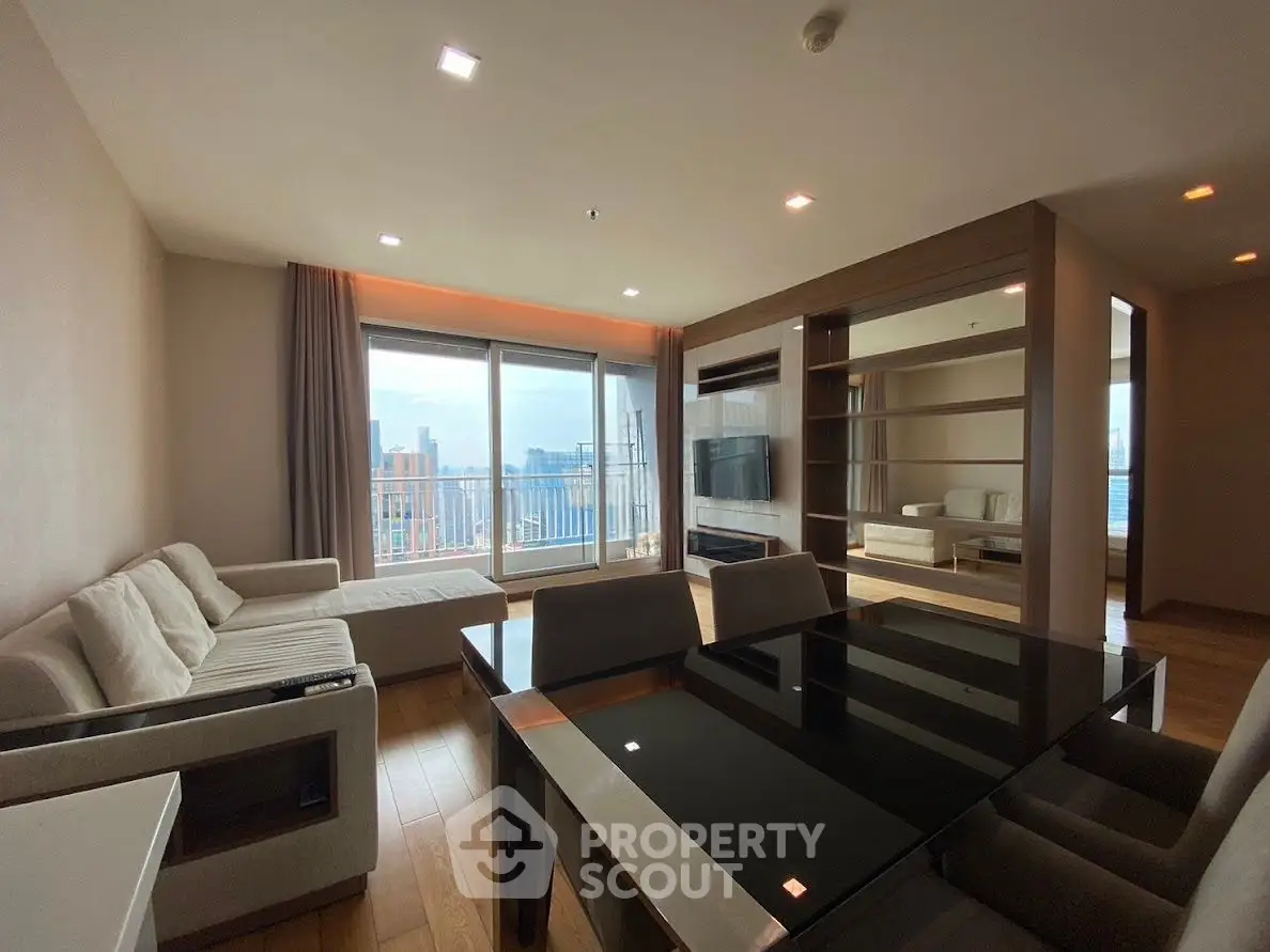 Spacious modern living room with city view and elegant dining area in high-rise apartment.