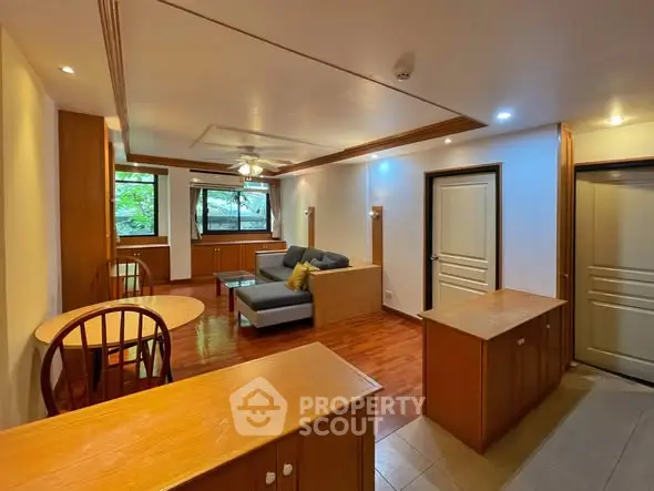 Spacious living room with wooden flooring and modern furniture, ideal for relaxation.