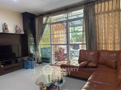 Spacious living room with leather sofa and large window for natural light