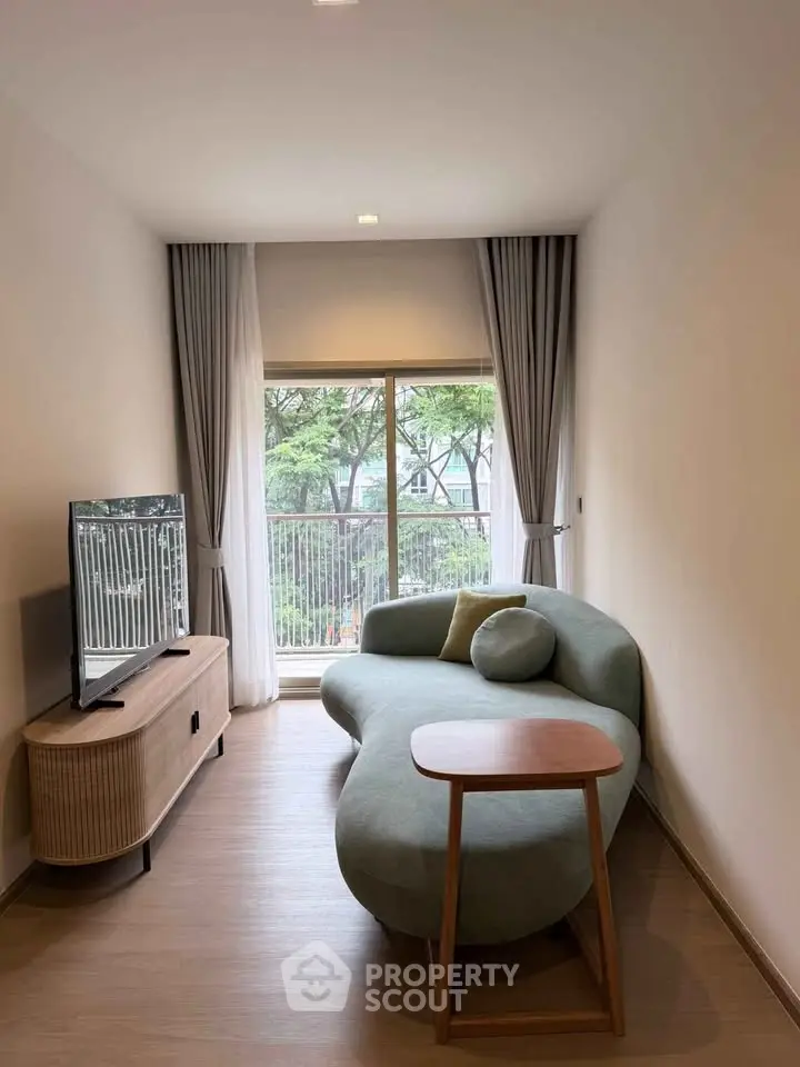 Modern living room with stylish curved sofa and large window view.