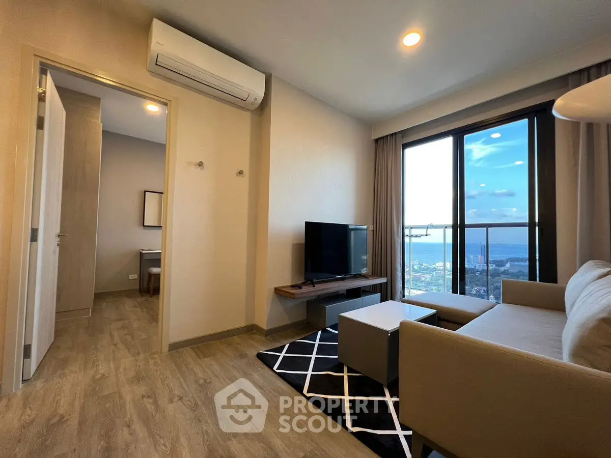 Modern living room with stunning city view, featuring sleek furniture and large windows.