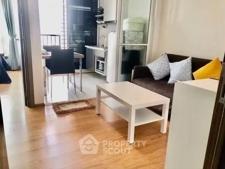 Cozy living room with modern furniture and open kitchen layout in a bright apartment.