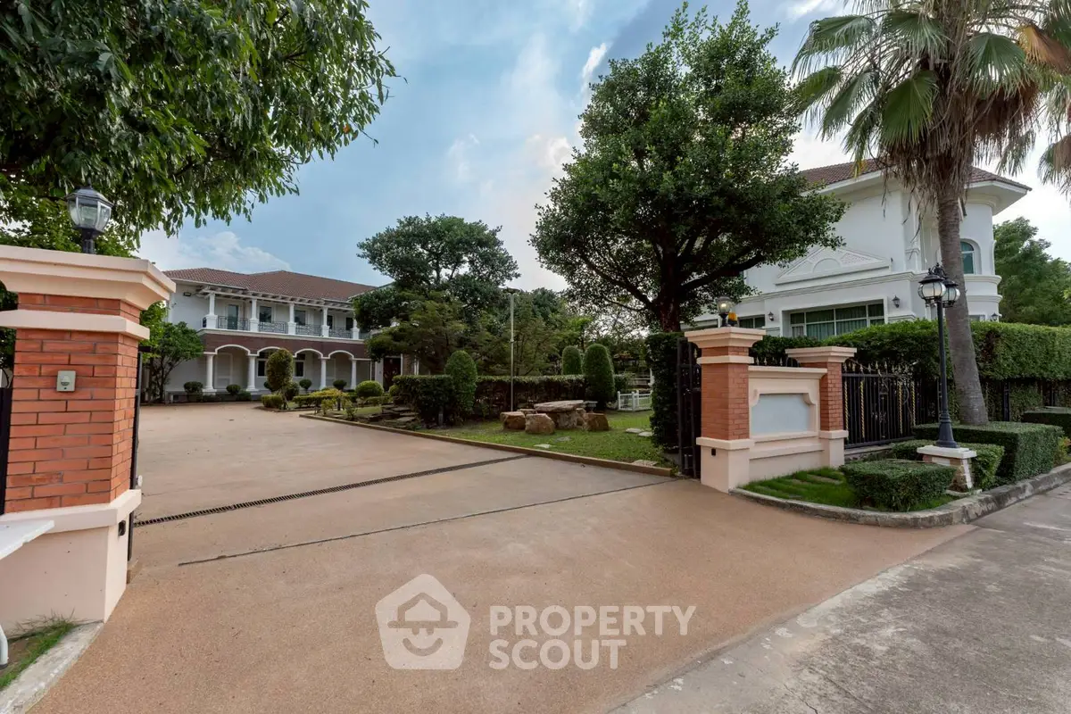 Luxurious estate with grand entrance and lush landscaping