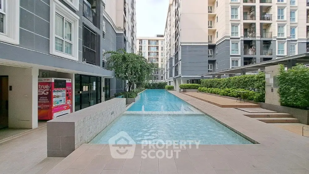 Luxurious condominium pool area with modern architecture and lush greenery.
