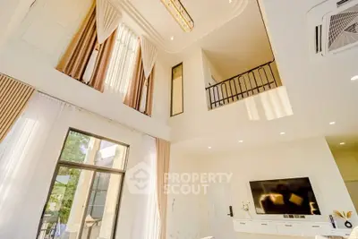 Luxurious high-ceiling living room with elegant decor and large windows