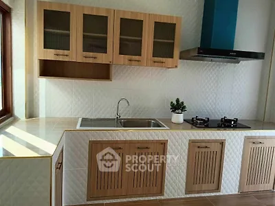 Modern kitchen with sleek cabinetry and gas stove, featuring a stylish backsplash and ample natural light.