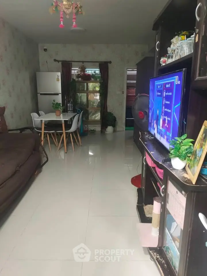 Spacious living room with modern decor and dining area, featuring a cozy sofa and entertainment setup.