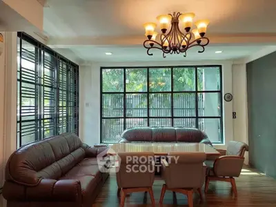 Spacious living room with elegant chandelier and large windows for natural light.