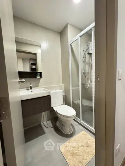 Modern bathroom with glass shower and sleek fixtures in a contemporary apartment.