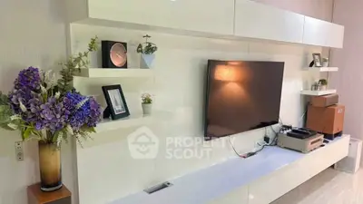 Modern living room with sleek white entertainment unit and large TV