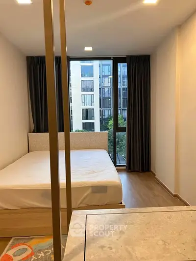 Modern bedroom with large window and city view in a stylish apartment