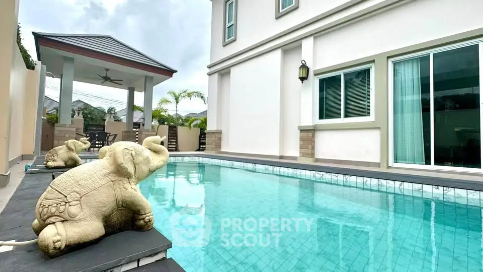 Luxurious home with a stunning pool and elegant outdoor seating area, perfect for relaxation and entertainment.