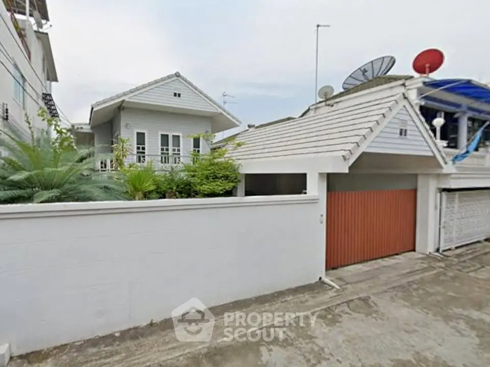 Charming suburban house with modern roof and lush greenery