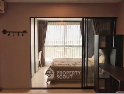 Cozy bedroom with large window and modern decor in a stylish apartment.