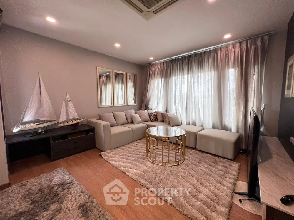 Elegant living room with modern decor, plush seating, and natural light for a cozy ambiance.