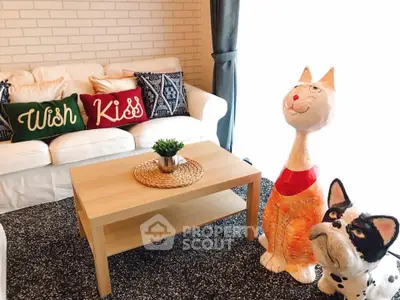 Charming living room with cozy sofa, playful cat sculptures, and stylish decor accents.