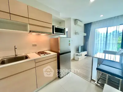 Modern open-layout kitchen and living room with sleek appliances and natural light.
