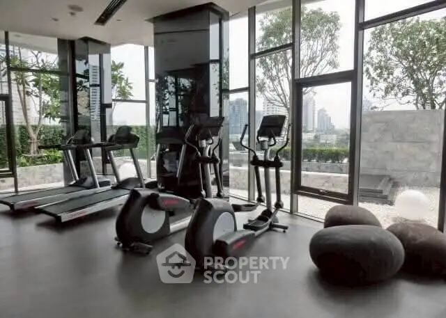 Modern gym with city view and state-of-the-art equipment in luxury building.