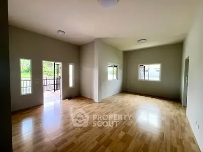 Spacious living room with wooden flooring and ample natural light