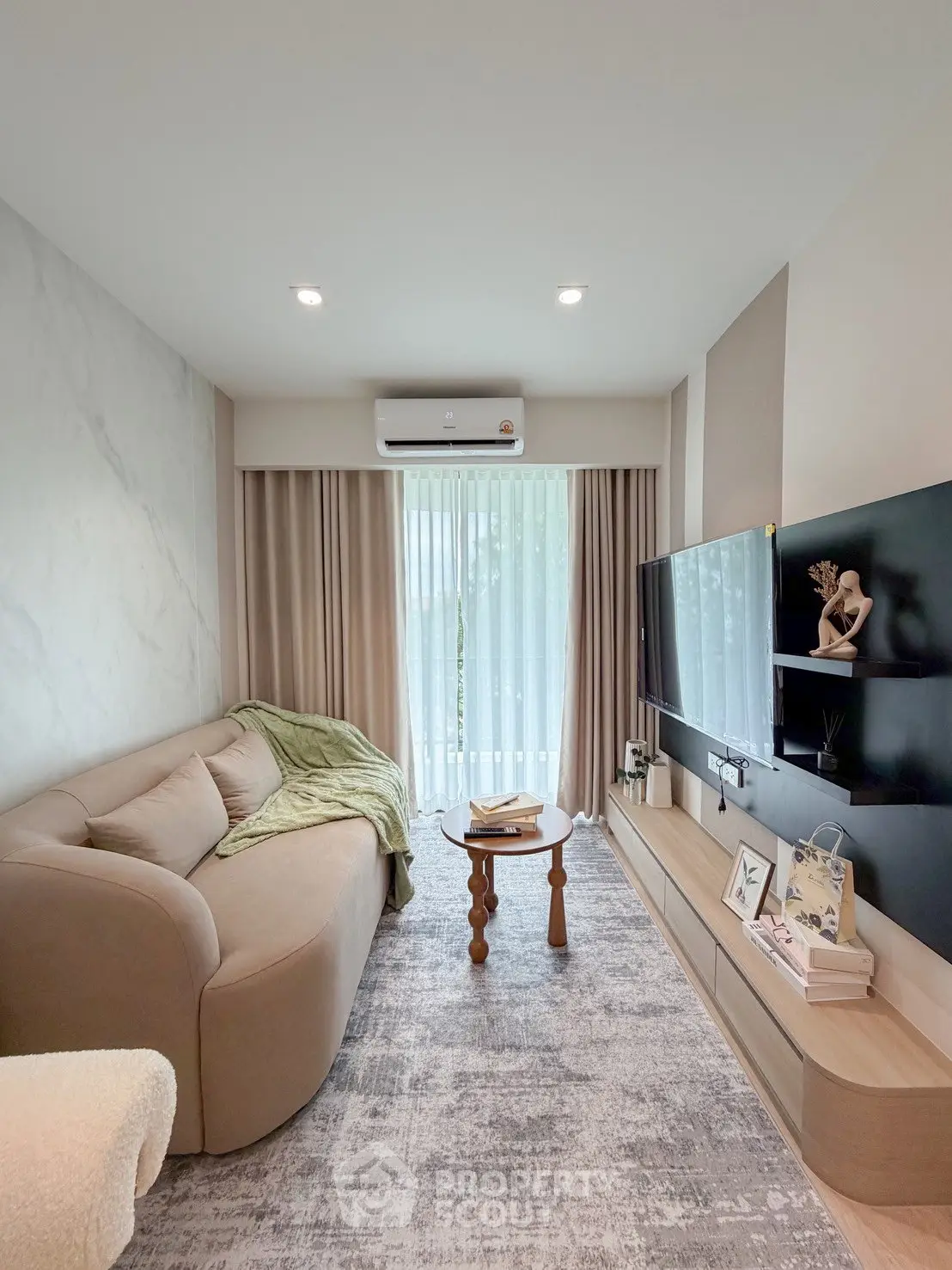 Modern living room with cozy sofa, stylish decor, and large window for natural light.