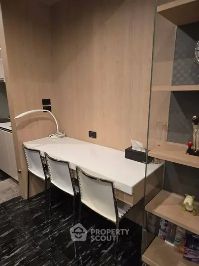 Modern study area with sleek desk and chairs, featuring elegant shelving and contemporary decor.