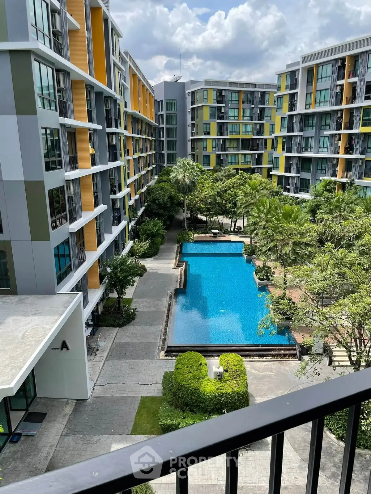 Modern apartment complex with pool and lush greenery, perfect for urban living.