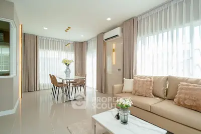 Modern living room with elegant decor and natural light, featuring a cozy sofa and stylish dining area.