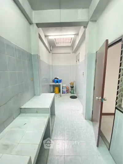 Spacious tiled utility room with ample storage and natural light, perfect for organizing household essentials.