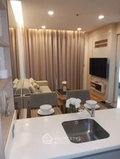 Modern living room with open kitchen, cozy seating, and elegant decor