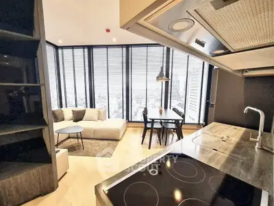 Modern open-layout kitchen and living room with city view, featuring sleek design and ample natural light.