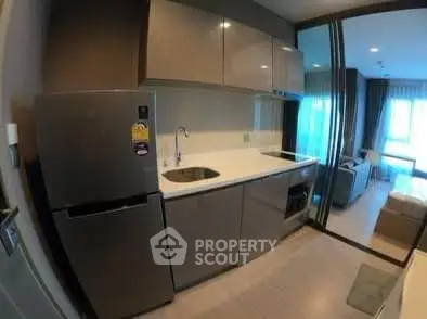 Modern kitchen with sleek cabinetry and stainless steel appliances in a stylish apartment.