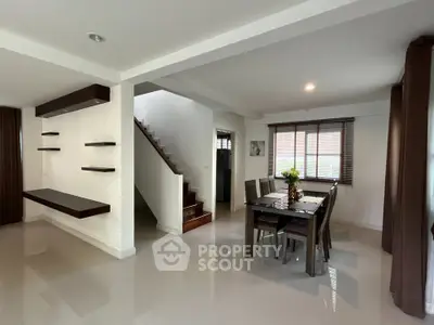 Spacious modern dining area with elegant staircase and natural light