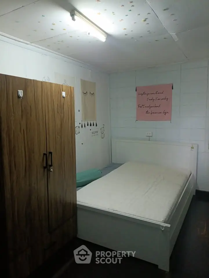 Cozy bedroom with wooden wardrobe and minimalist decor, perfect for a peaceful retreat.