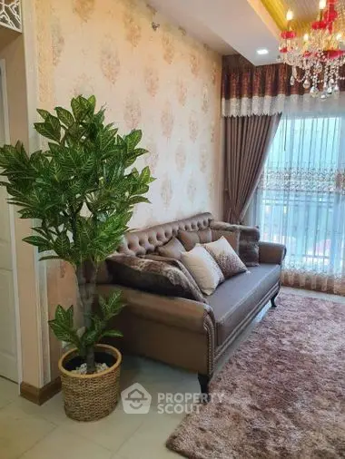 Elegant living room with classic tufted sofa, ornate wallpaper, plush rug, and a vibrant potted plant, complemented by a luxurious chandelier and sheer curtains.
