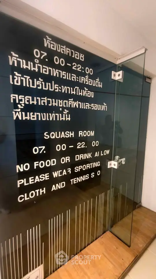 Modern squash room entrance with glass door and clear signage