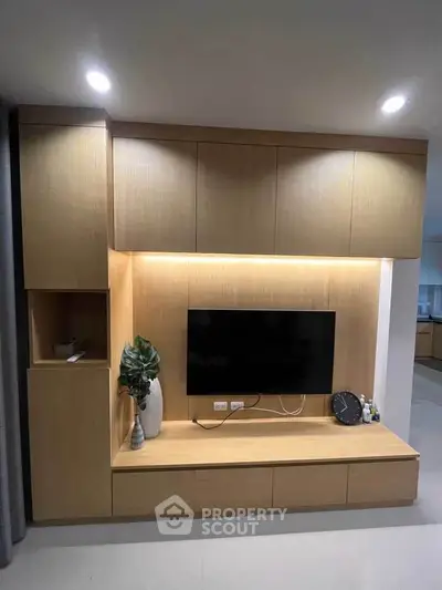 Modern living room with sleek wooden TV unit and ambient lighting