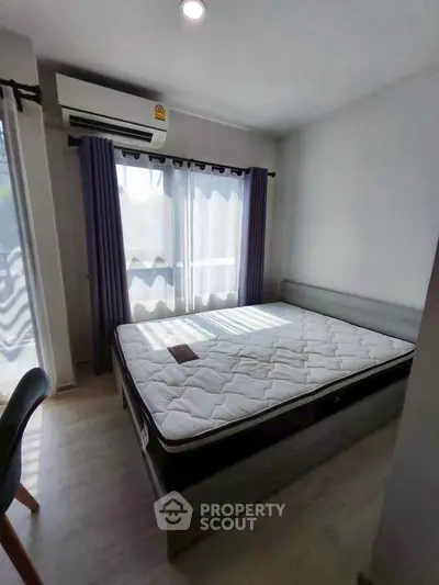 Bright bedroom with large window and air conditioning, featuring a comfortable bed and modern decor.