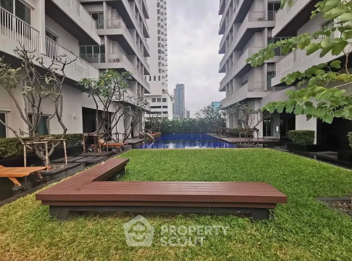 Luxurious apartment complex with modern pool and lush garden area