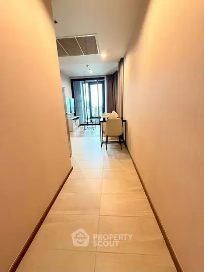 Spacious hallway leading to a modern living area with natural light and stylish decor.