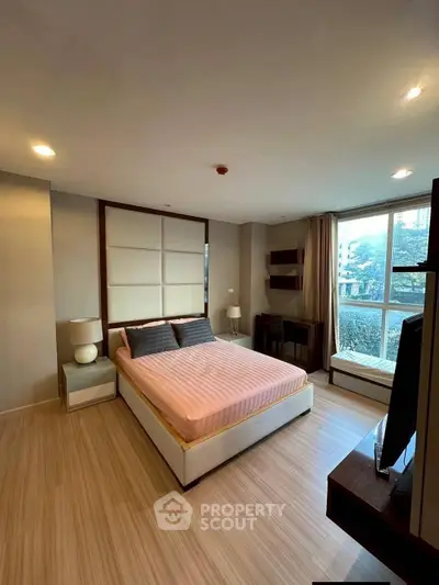 Spacious bedroom with large window and modern decor in a luxury apartment.