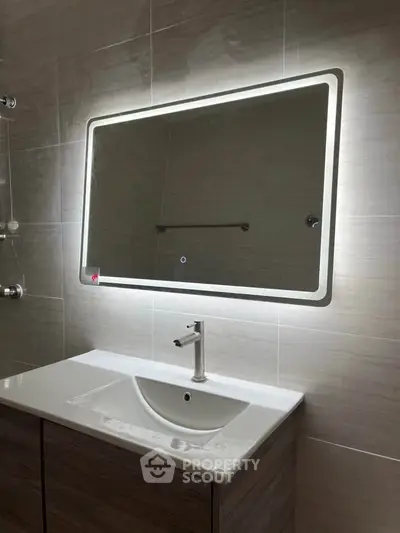 Modern bathroom with illuminated mirror and sleek sink design
