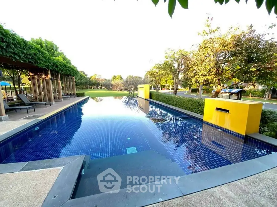 Luxurious outdoor pool with modern design and lush greenery in a serene setting.