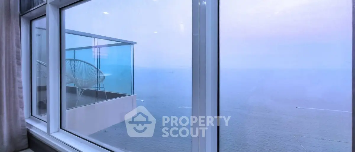 Stunning ocean view from high-rise balcony with modern glass railing.