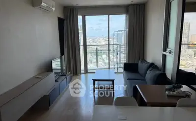 Spacious living room with city view, modern furniture, and large windows for natural light.