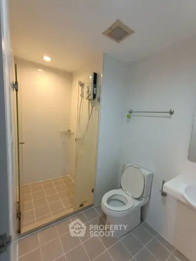 Modern bathroom with glass shower and sleek fixtures in a contemporary home.
