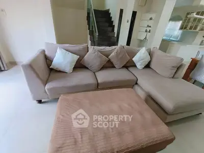 Spacious living room with cozy sectional sofa and modern staircase in elegant home