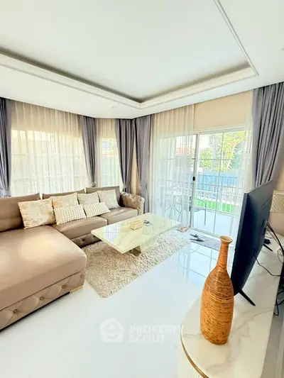 Spacious living room with elegant decor and large windows offering abundant natural light.