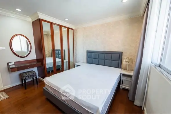 Spacious bedroom with elegant decor and ample natural light