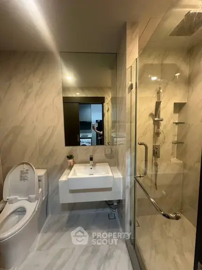 Modern bathroom with sleek design, glass shower, and elegant fixtures in a luxury apartment.