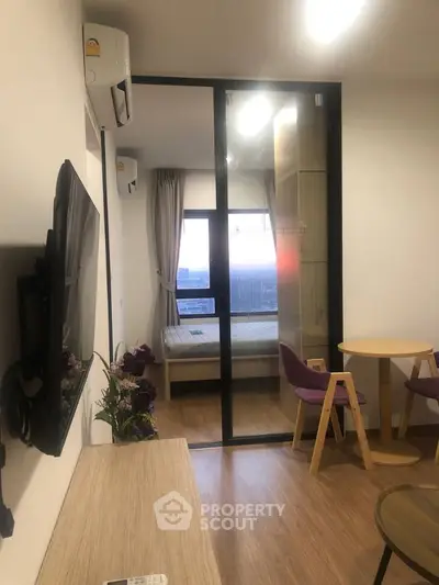 Modern apartment interior with cozy living area and bedroom view, featuring stylish furniture and natural light.